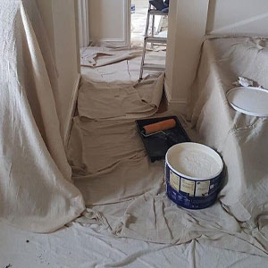 Cotton twill dust sheet covering a sofa during a living room decorating job