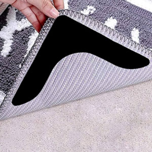 Rug gripper tape applied to the corner of a rug on a polished wooden floor